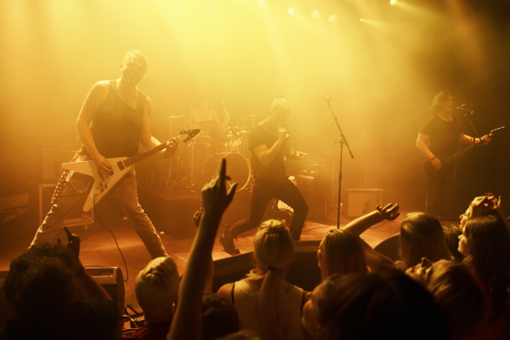 band on a stage with audience yellow lighting