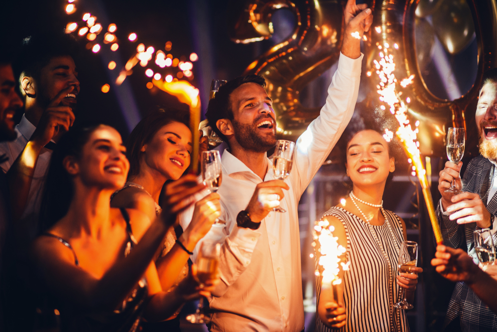 Group of friends celebrating with champagne and fireworks