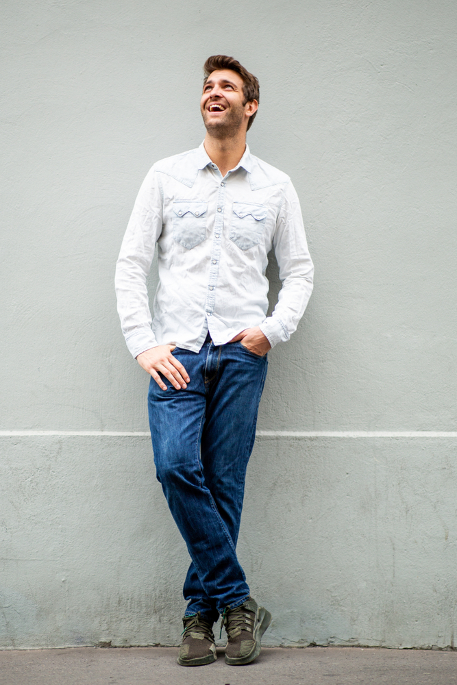 man leaning against wall looking up