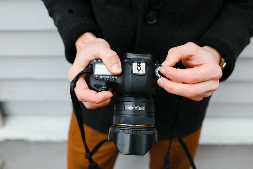 photographer adjusts the camera settings top view