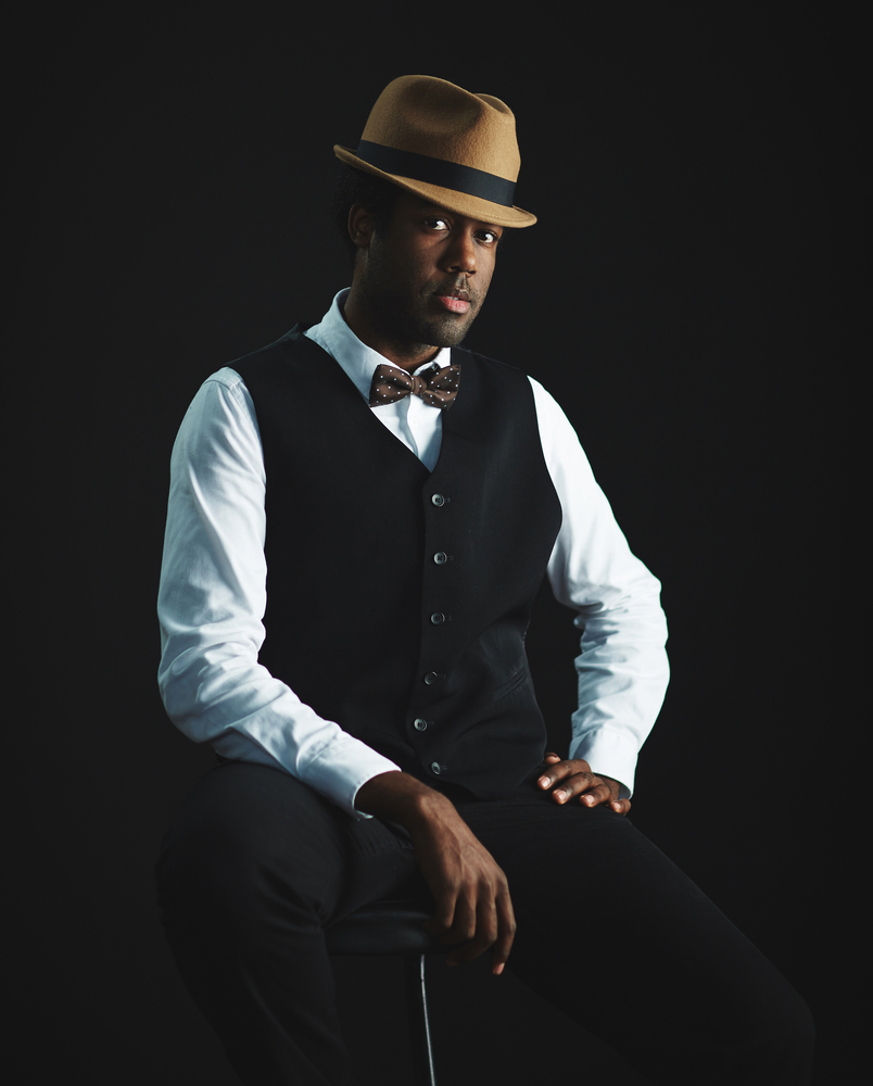 Well dressed man seated on a stool